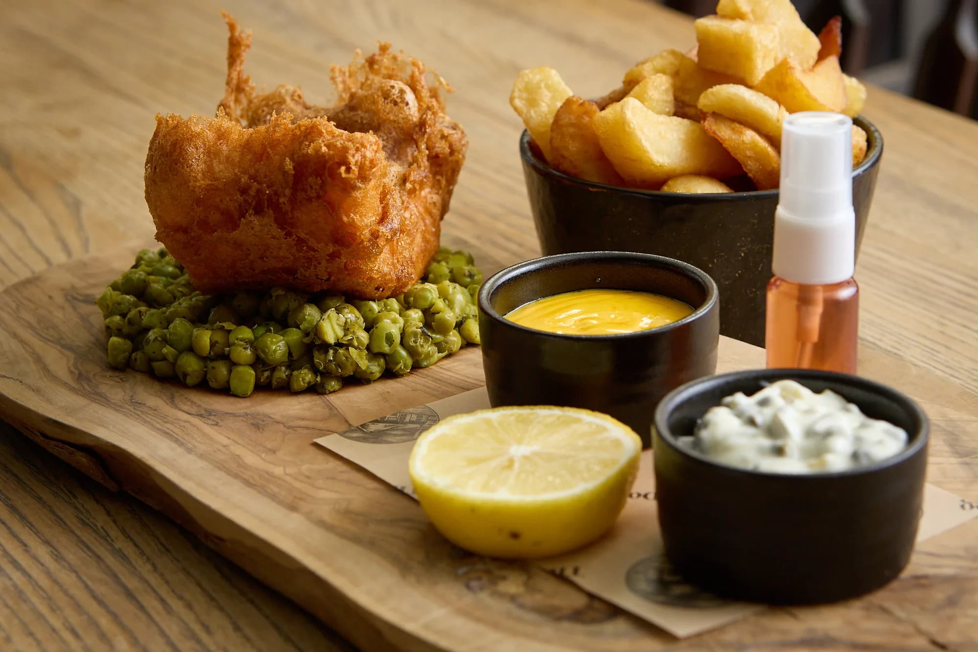 Battered fish, chunky chips, peas and sauces served at The Old Dog